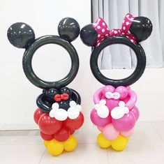 two mickey and minnie mouse balloons sitting next to each other