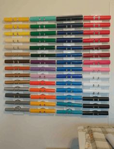 there are many different colored pens hanging on the wall