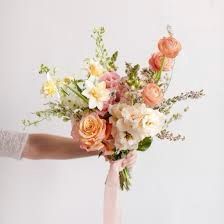 a woman holding a bouquet of flowers in her hand