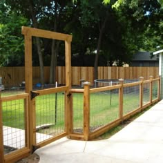 a fenced in area with grass and trees