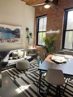 a living room filled with furniture and a large window next to a wall mounted painting