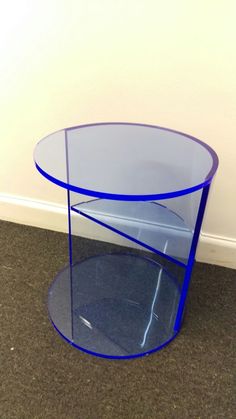 a blue glass table sitting on top of a carpeted floor