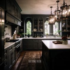 a large kitchen with lots of counter space and lights hanging from the ceiling above it