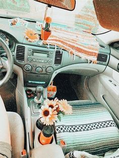 the interior of a car with flowers in vases on the dash board and sunroof