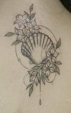 the back of a woman's neck with flowers and seashells on it