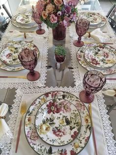 the table is set with flowers and plates