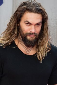 a man with long hair and beard wearing a black shirt