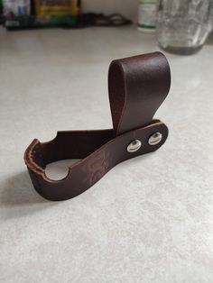 a pair of brown leather eyeglasses resting on a counter top next to a bottle opener