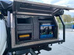 the back end of a truck with its doors open and tools in it's cargo compartment