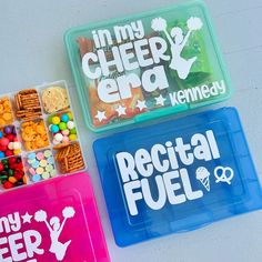 three plastic lunch boxes filled with different types of snacks and candy in each one, including crackers, pretzels, and cereal