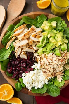 a salad with chicken, lettuce, cranberries and oranges