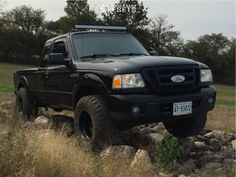 a black truck is parked on some rocks