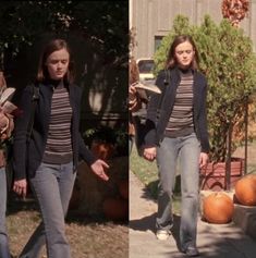 two women are walking down the street with pumpkins in their hands and one is wearing jeans