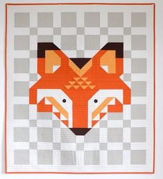 an orange and white quilt with a fox on it's face in the middle