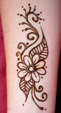 a woman's arm with a henna tattoo on the side of her leg