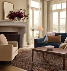 a living room filled with furniture and a fire place in front of a window covered in curtains