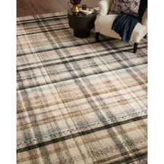 an area rug with plaid pattern on it and a white chair in the corner next to it