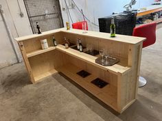 a wooden shelf with wine glasses and bottles on it in a room filled with furniture