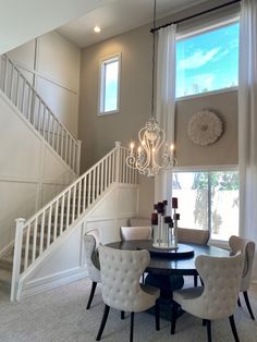 a dining room table with four chairs and a chandelier hanging from the ceiling