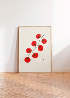 an art piece with red flowers on it in front of a white wall and wooden floor