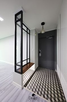 an empty room with a black and white checkered floor, glass partitions, and a door