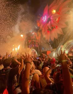 a large group of people at a concert with fireworks and confetti in the air