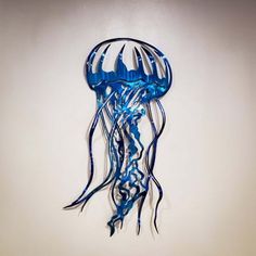 a blue jellyfish hanging from the side of a wall