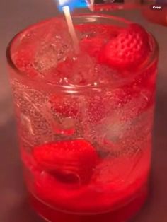 a red drink with ice and strawberries in it