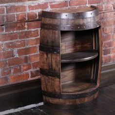 a wooden barrel shelf next to a brick wall