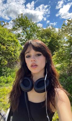 a woman with headphones standing in the grass