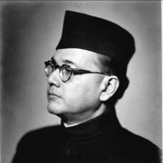 an old black and white photo of a man in a priest's outfit with glasses