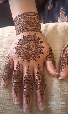 a woman's hand with henna tattoos on it