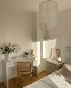 a bedroom with a bed, desk and chair next to a lamp hanging from the ceiling