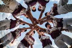 a group of people standing in a circle holding hands and making a heart shape with their hands