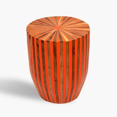 an orange and black striped wooden stool on a white background with shadow from the top