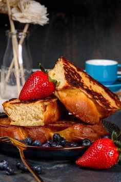 Slices of vegan french toast are stacked on top of each other on a dark blue plate. Fresh strawberries and blueberries are on the plate next to the french toast. A cup of coffee is blurred in the background. Chocolate French Toast, Perfect French Toast, Breakfast Gluten Free, French Toast Ingredients, Vegan Cinnamon Rolls, Cozy Weekend