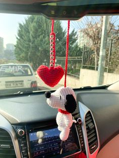 a stuffed dog hanging from the dashboard of a car