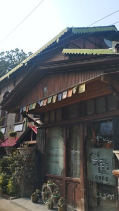 an old wooden building with lots of windows on the front and side of it's roof