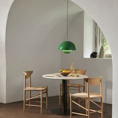 a table with two chairs and a bowl of fruit on it in front of an arch