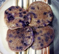 three blueberry pancakes on a plate with silverware