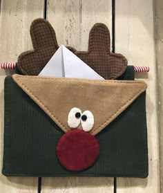 an envelope decorated to look like a reindeer's head with eyes and nose sticking out of it