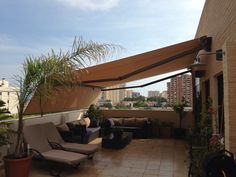 an outdoor living area with couches, chairs and plants on the roof top terrace