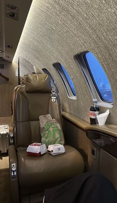 the inside of an airplane with two windows and leather recliners on each side