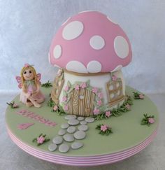 a birthday cake with a mushroom house and fairy figurines