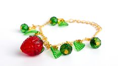 Handmade "Gift of the Forest" Fruit Strawberry Charm Chain Beaded Wire Wrapped Bracelet Glass Leaves Adjustable Clasp Leaf Charm Jewellery Step into a magical forest with our "Gift of the forest" bracelet. This enchanting piece features a delightful Strawberry charm paired with intricately crafted glass leaves, evoking the playful spirit of woodland treasures. Each glass bead captures the essence of nature's elegance, while the strawberry charm adds a touch of whimsical charm. Details: Length: 1 Green Summer Jewelry With Fruit Design, Beaded Fruit Bracelet, Beaded Strawberry Bracelet, Strawberry Charm Bracelet, Strawberry Chain Bracelet, Fruit Bracelet, Strawberry Charm, Fruit Jewelry, Cute Fruit