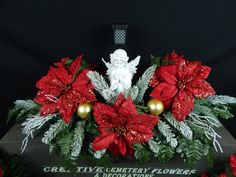 a christmas arrangement with poinsettis and greenery