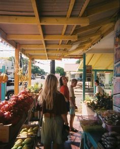 people are shopping at an outdoor market with fruits and vegetables