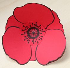 a red flower cut out from paper on a table