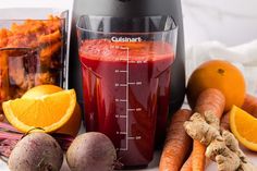 a blender filled with liquid surrounded by fruits and vegetables