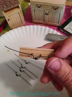 a person is holding a piece of wood in front of a plate with small objects on it